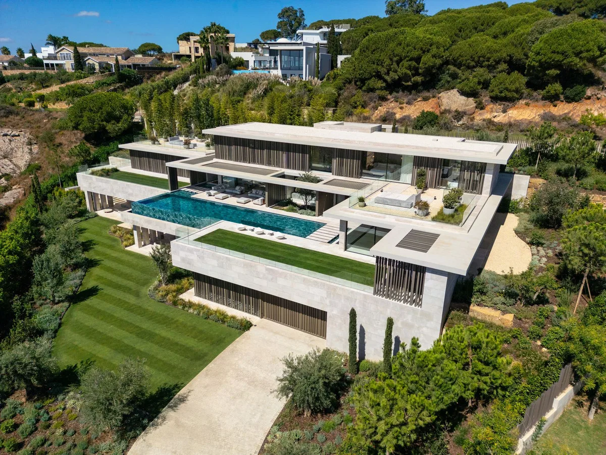 Vista aérea de la villa de ARK Architects en La Reserva de Sotogrande, en terrazas con piscinas y jardines